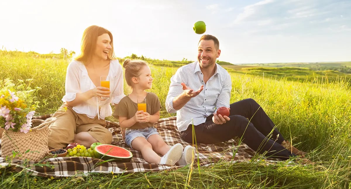 A father and mother have a picnic with their duaghter